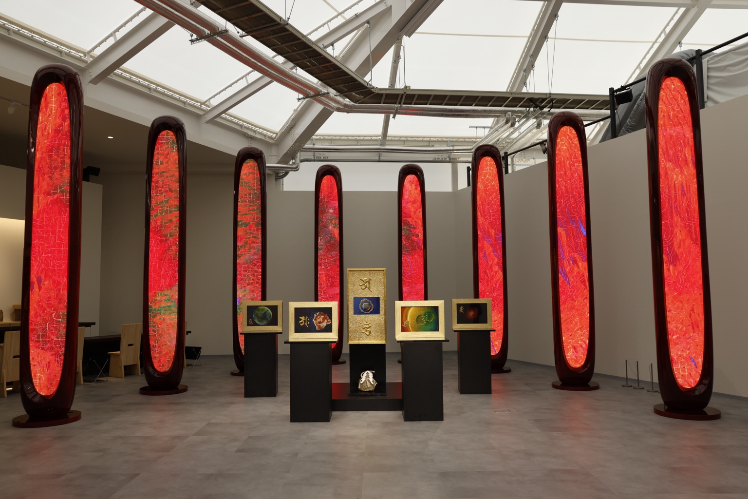 赤く光る縦長の作品と、額装されたいのちの作品が並ぶART TO SATORIの展示空間